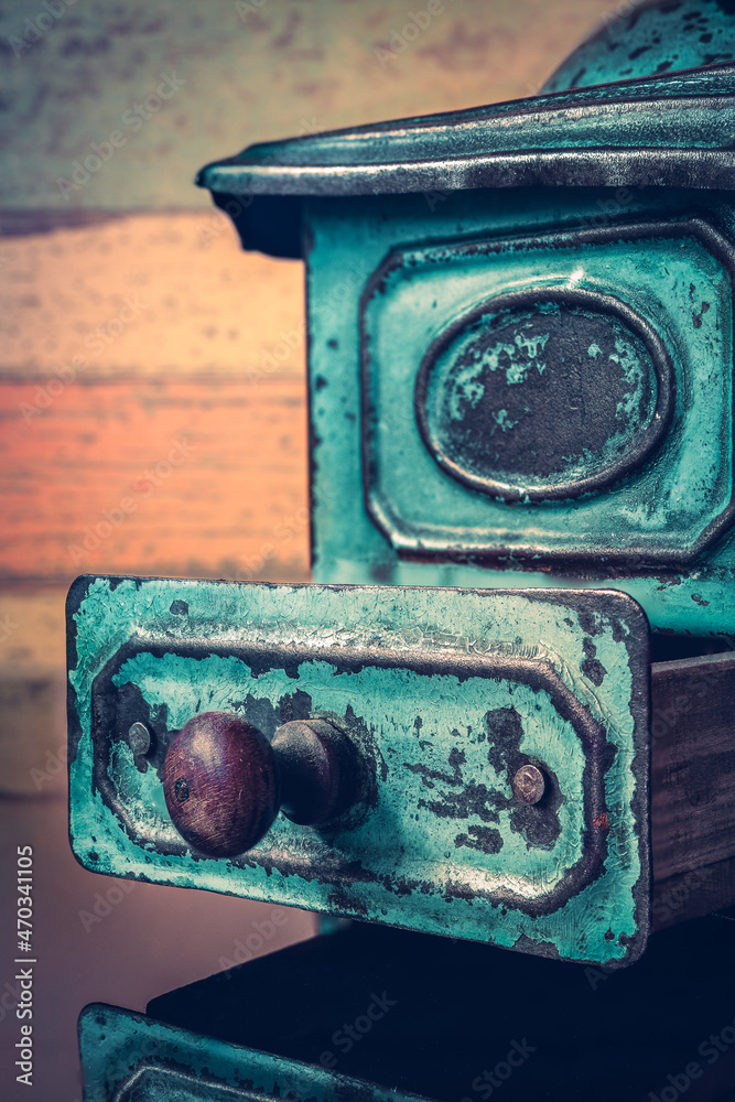 beautiful, turquoise, antique coffee grinder on an orange background