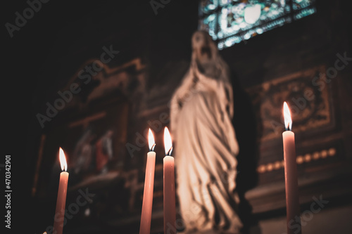 Candles lit in the church with the altar and christian icons in the background. Roman Catholic religion. Religious concept