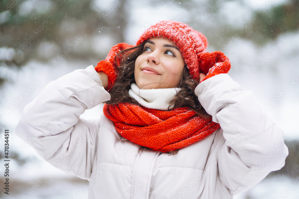 Young woman in winter style clothes against the backdrop of snowy forest. Nature, holidays, rest, travel concept.