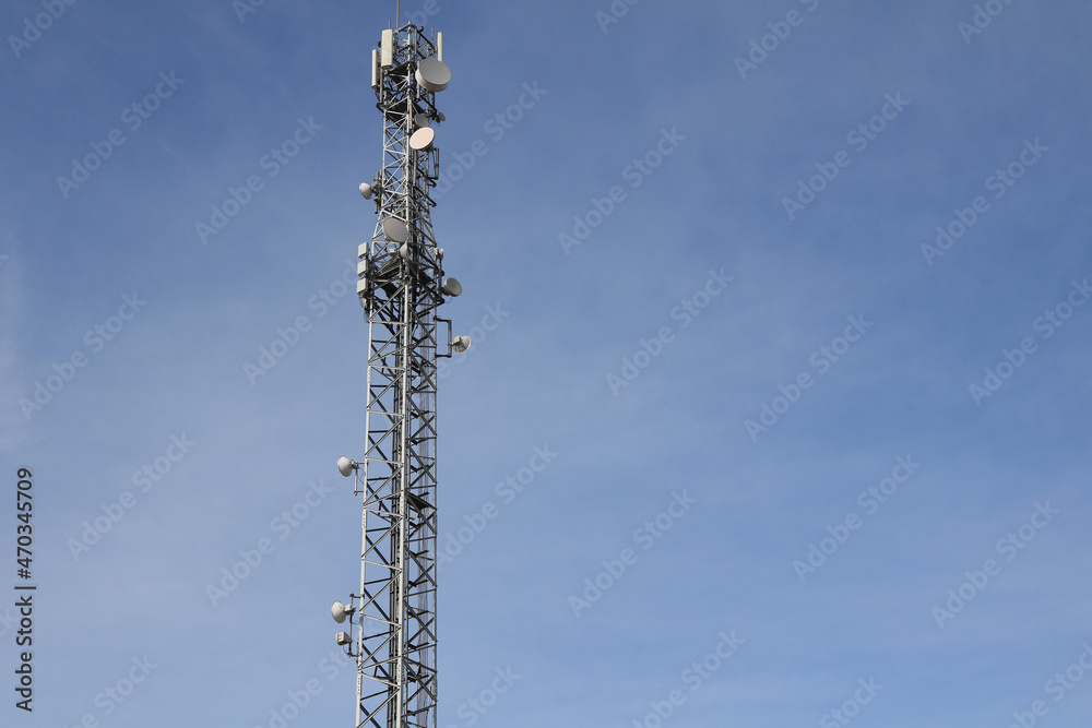 Communication tower on a blue sky background, selective focus Communication tower on a blue sky background, selective focus