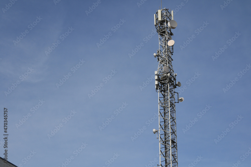 Communication tower on a blue sky background, selective focus Communication tower on a blue sky background, selective focus