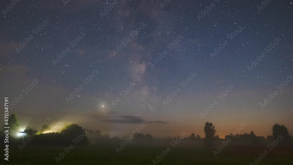 Timelapse of the movement of the starry night sky with the milky way over a field with fog. Timelapse of the starry night sky with clouds Timelapse of the movement of the starry night sky with the milky way over a field with fog. Timelapse of the starry night sky with clouds