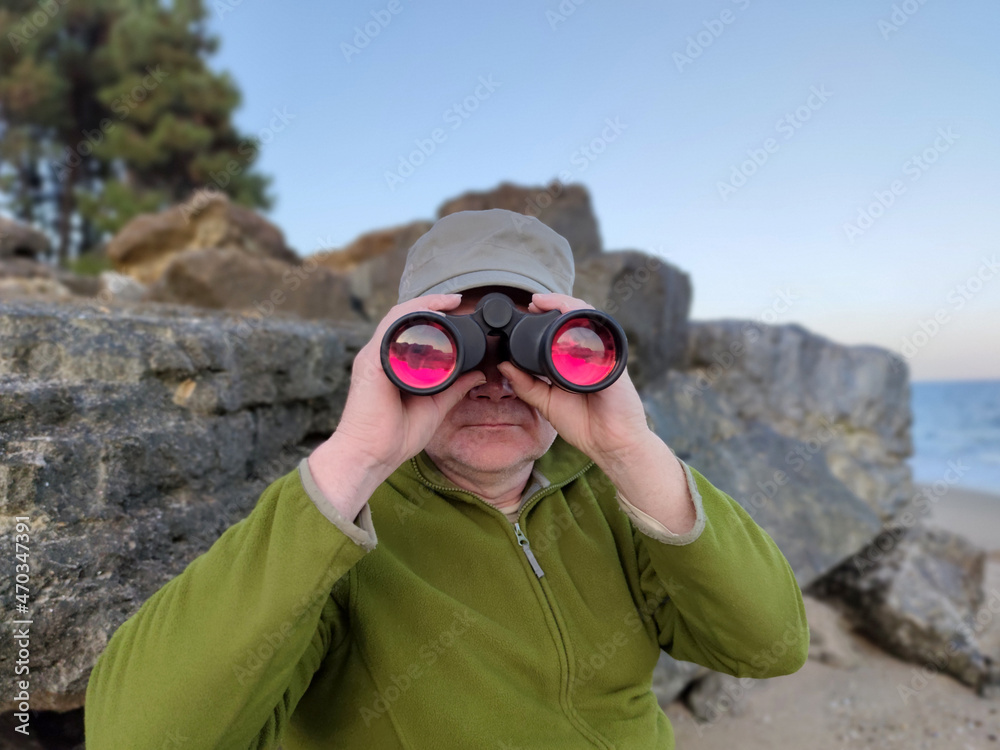 a man looking through binoculars on the seashore a man looking through binoculars on the seashore