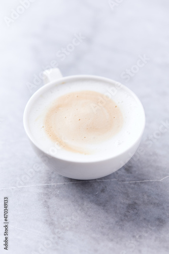 Coffee with milk on bright stone background. Close up.