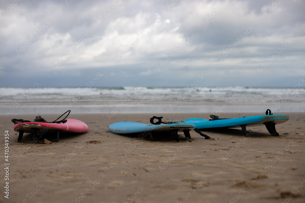 surf boards from a surf school at the beach of soulac-sur-mer at the atlantic ocean in France with wavy sea and dramatic sky in the background surf boards from a surf school at the beach of soulac-sur-mer at the atlantic ocean in France with wavy sea and dramatic sky in the background