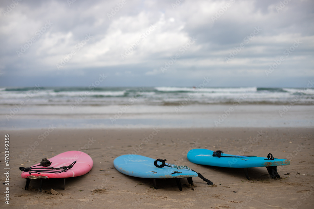 surf boards from a surf school at the beach of soulac-sur-mer at the atlantic ocean in France with wavy sea and dramatic sky in the background surf boards from a surf school at the beach of soulac-sur-mer at the atlantic ocean in France with wavy sea and dramatic sky in the background