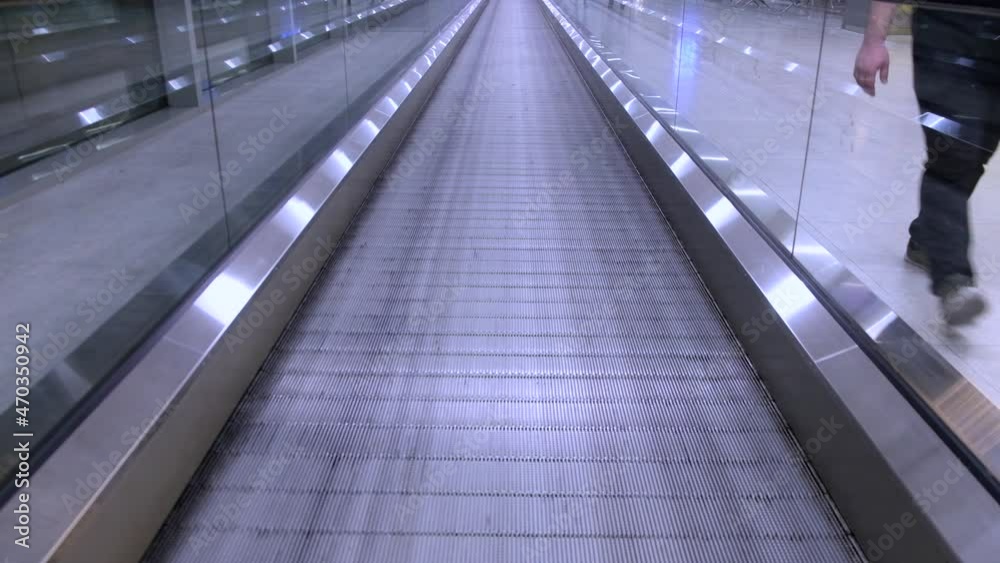 First person view to moving walkway. Moving pathway at airport First person view to moving walkway. Moving pathway at airport