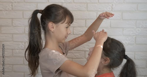 Girls measuring height. A young teen measure her height with her small sister in the room.