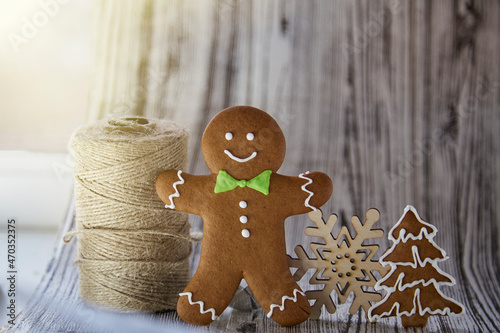 Christmas homemade gingerbread cookies with craft thread and wooden snowlake. Festive aesthetic card onwooden background. Christmas atmosphere. Merry Christmas and home coziness concept photo