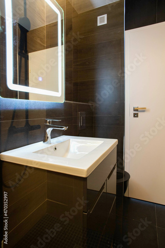 modern bathroom with dark furniture and spotlights