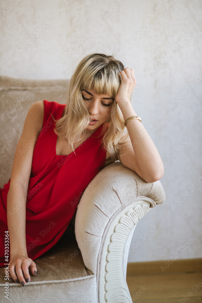 Naklejka premium Portrait of beautiful blond young woman wearing red dress