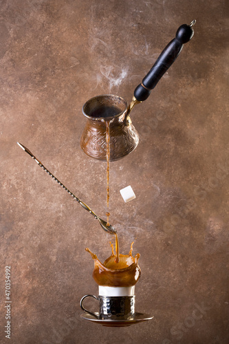 levitating coffee and turk on brown background. Splashes of coffee. turkish coffee. photo