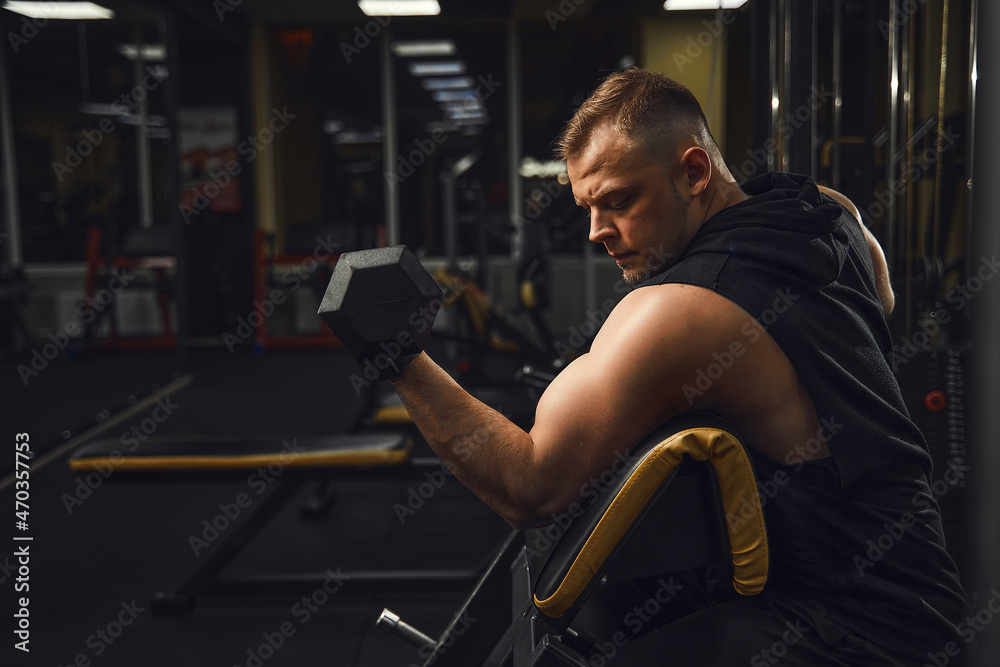 Sexy man in the gym with dumbbells. Sporty man with big muscles and a broad back trains in the gym, fitness and pumped-up abdominal press. Russia, Sverdlovsk, 2 June 2018 Sexy man in the gym with dumbbells. Sporty man with big muscles and a broad back trains in the gym, fitness and pumped-up abdominal press. Russia, Sverdlovsk, 2 June 2018