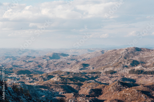 Aerial panoramic view of rock landscape of brown mountains and blue sky with white clouds. Landscape in mountains. Travel background for a post, screensaver, wallpaper, postcard, poster, banner, cover