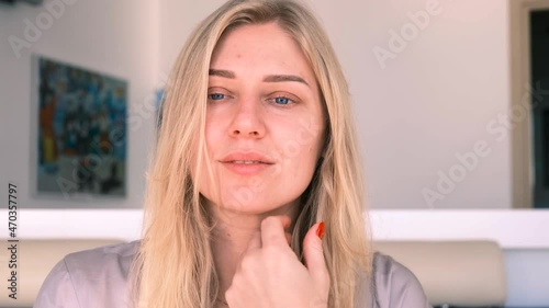Natural beauty and self-care in 30 years. Portrait of a young beautiful blonde woman gently touching her face, looking into the camera. 4k, slow motion