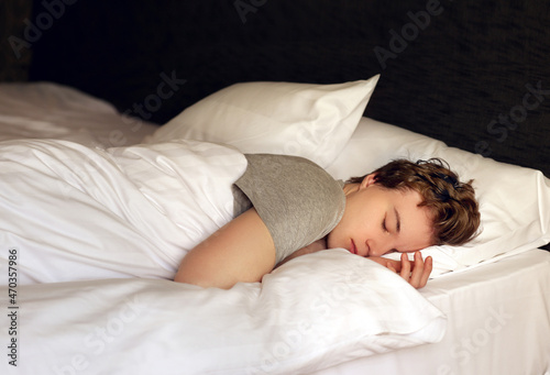Fotografie young sleeping man lying on the bed