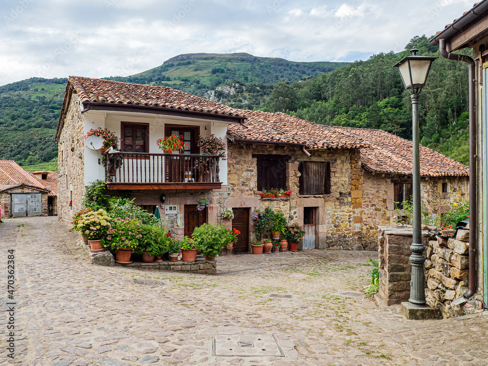 Vista del paisaje de casas antiguas de piedra con las montañas verdes al fondo, en el pueblo de Carmona, en la Cantabria rural de España, verano de 2020 Vista del paisaje de casas antiguas de piedra con las montañas verdes al fondo, en el pueblo de Carmona, en la Cantabria rural de España, verano de 2020