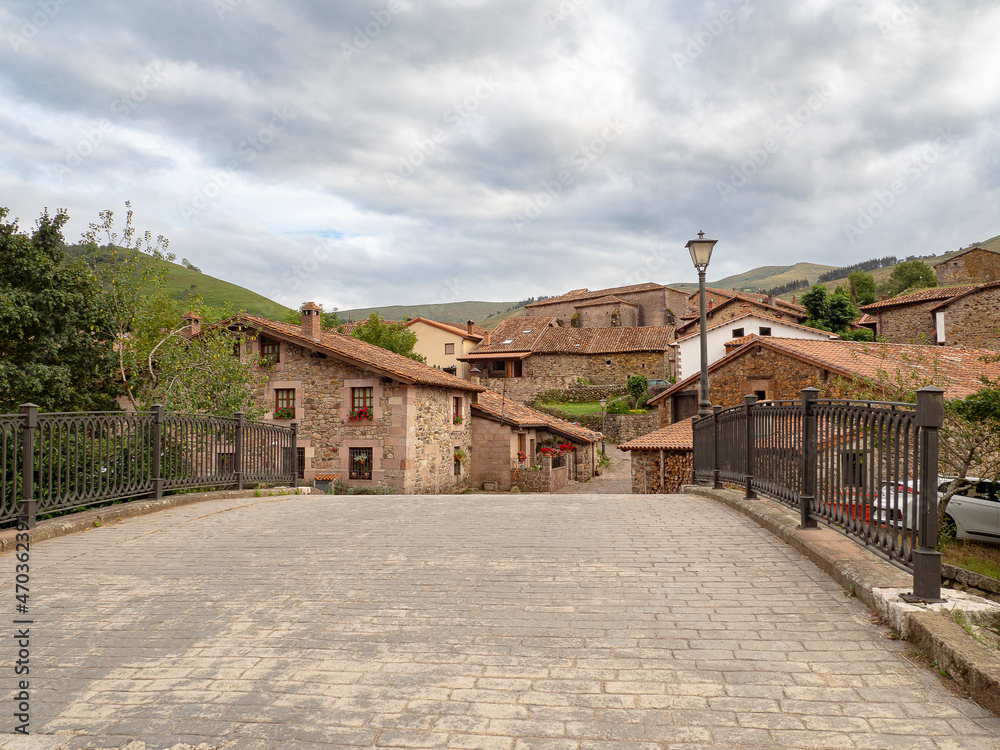 Vista del paisaje de cielo nublado y de casas antiguas de piedra en el pueblo de Carmona, en la Cantabria rural de España, verano de 2020