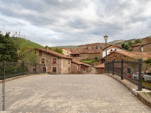 Vista del paisaje de cielo nublado y de casas antiguas de piedra en el pueblo de Carmona, en la Cantabria rural de España, verano de 2020 © acaballero67