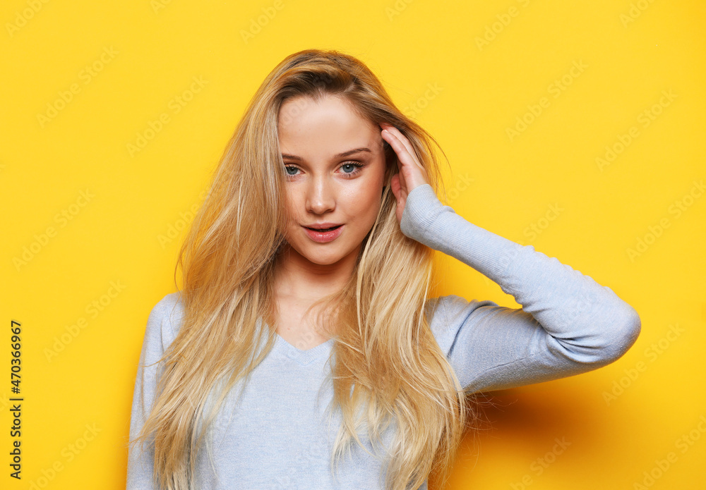 Studio shot of good-looking beautiful woman isolated against yellow background. Studio shot of good-looking beautiful woman isolated against yellow background.