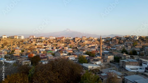A historical muslim town. Azan time and mosque minarets. A snowy mountain landscape in the background. Very nice drone footage video