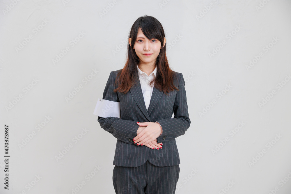 スーツを着て手を組み微笑むアジア人女性 スーツを着て手を組み微笑むアジア人女性