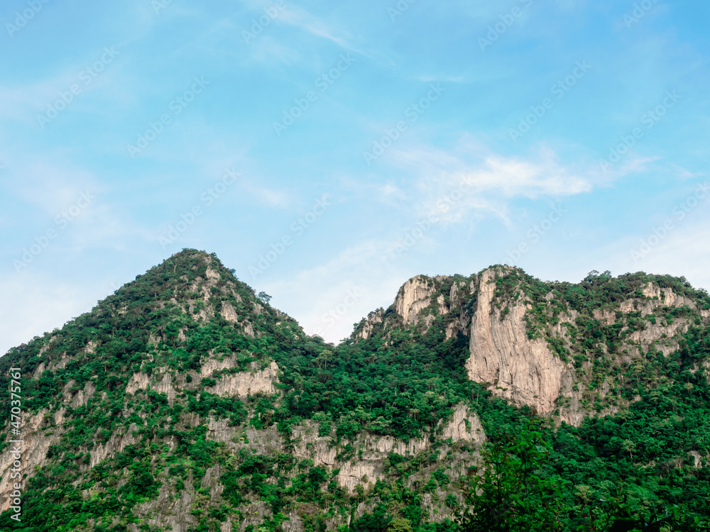 Nature background. Green tree, jungle on the beautiful shape mountain on blue sky and cloud with sunshine on sunny day.