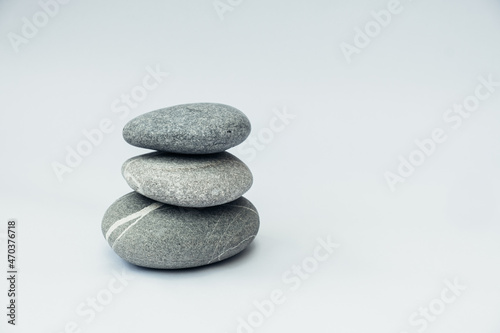 Stone cairn on light background, stones tower, simple poise stones. Purity harmony and Balance Concept.