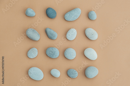 Set of sea stones of a round form on beige background. Top view of a collection of smooth pebbles.