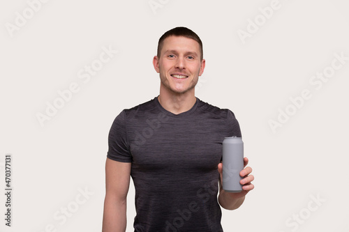 Sportman Holding Tin Can Drink. Energy Drink for Sport. Man with Can in Hands. photo
