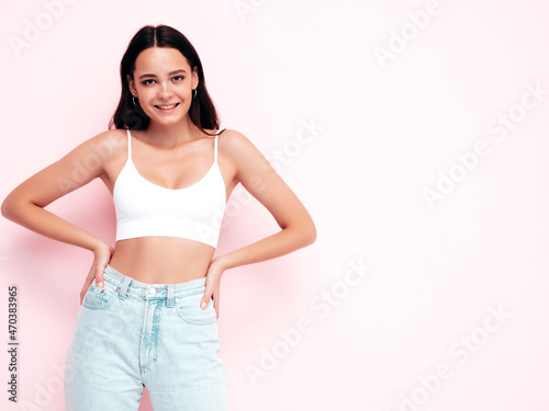 Young beautiful smiling female in trendy summer clothes. Sexy carefree woman posing near pink wall in studio. Positive brunette model having fun and going crazy. Cheerful and happy