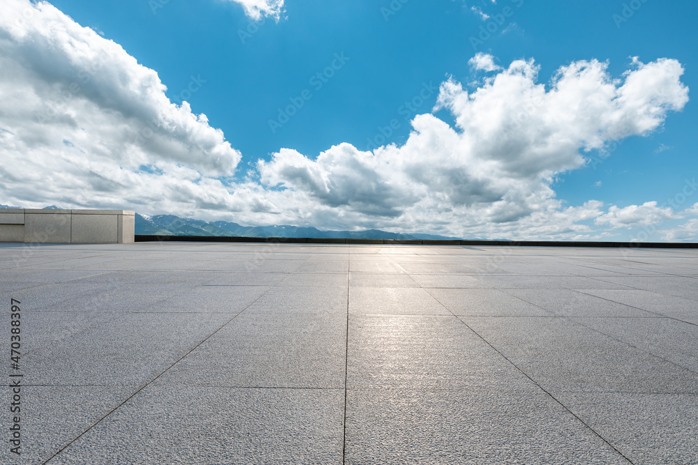 Empty square floor and mountains under blue sky