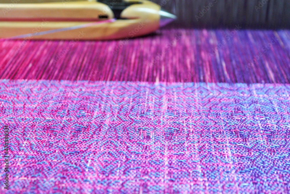 Fototapeta premium Multicolored texture textile in a wooden loom machine.