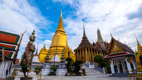 Beautiful landscape of Wat Phra Si Rattana Satsadaram (Wat Phra Kaew) or Temple of the Emerald buddha over blue sky and white cloud. Most popular temple of tourist in Bangkok, Thailand