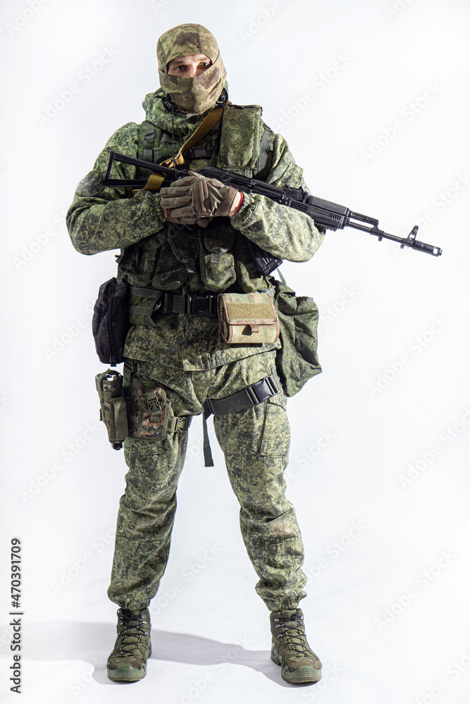Members of the special purpose unit. A Russian special forces soldier with assault rifle aiming from a machine gun on a white background Members of the special purpose unit. A Russian special forces soldier with assault rifle aiming from a machine gun on a white background