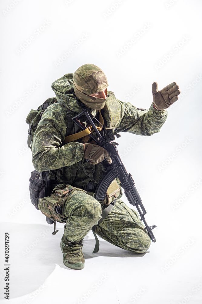 Members of the special purpose unit. A Russian special forces soldier with assault rifle aiming from a machine gun on a white background Members of the special purpose unit. A Russian special forces soldier with assault rifle aiming from a machine gun on a white background