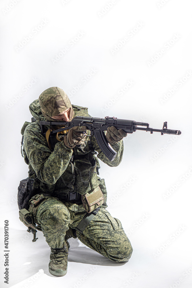 Members of the special purpose unit. A Russian special forces soldier with assault rifle aiming from a machine gun on a white background Members of the special purpose unit. A Russian special forces soldier with assault rifle aiming from a machine gun on a white background