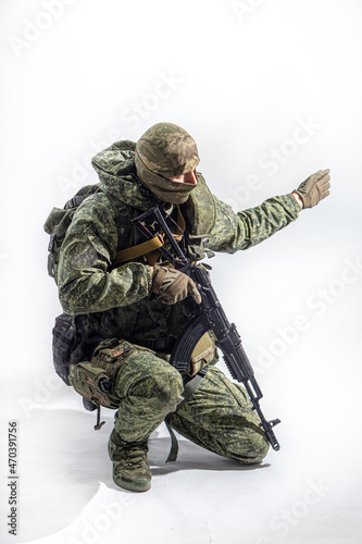 Members of the special purpose unit. A Russian special forces soldier with assault rifle aiming from a machine gun on a white background