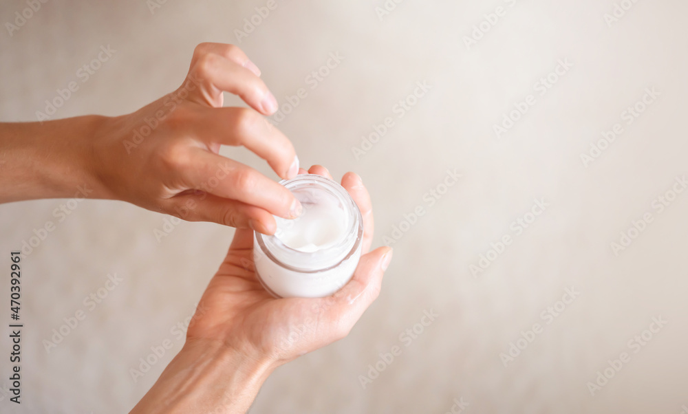 Female hands hold a jar of moisturizing cream. Female hands hold a jar of moisturizing cream.