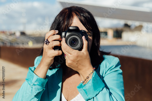 Woman taking a photo with her digital camera, Professional photographer shooting a picture.