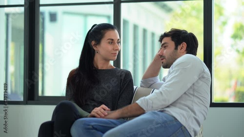 unhappy couple comforting each other sitting on sofa at home