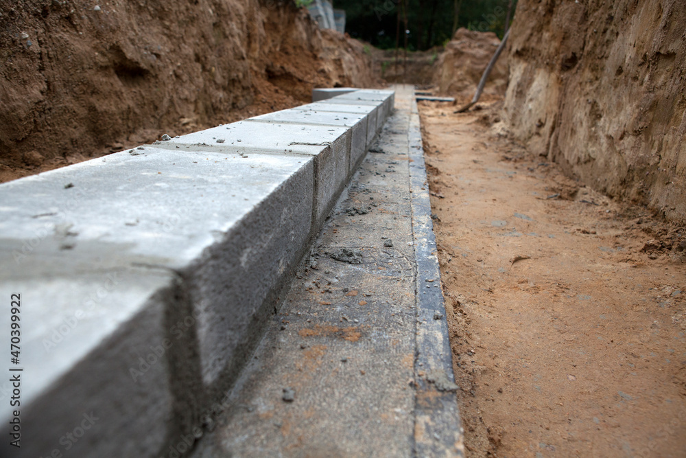 Fototapeta premium Bricklaying of foundation blocks for a new home. House construction concept