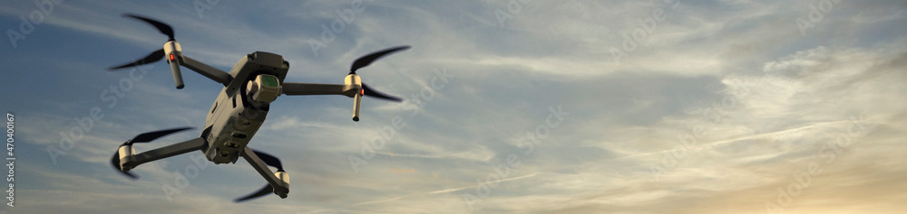 Drone flying at sunset against dark blue sky Drone flying at sunset against dark blue sky