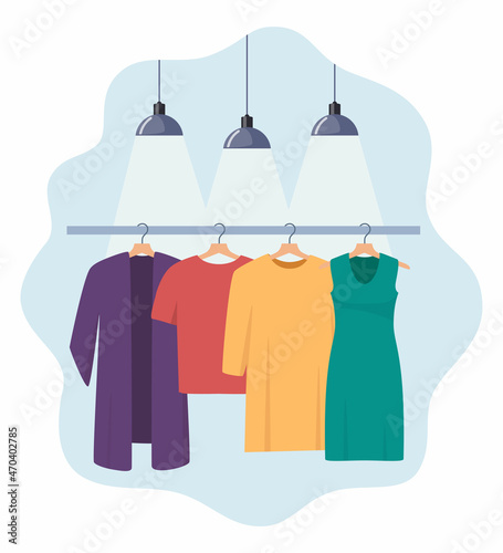 Clothes hang on a hanger, illuminated by lamps. Fashion boutique, assortment showroom. Women's personal wardrobe, dressing room. Dress, tunic, blouse on hangers. Vector illustration.