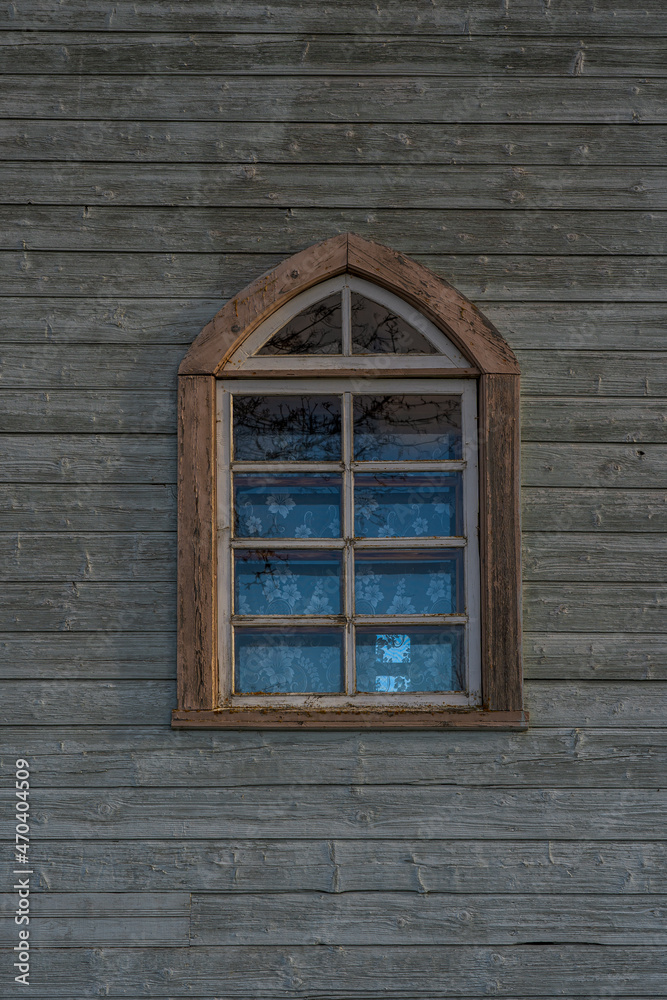 One window on a wooden church wall.