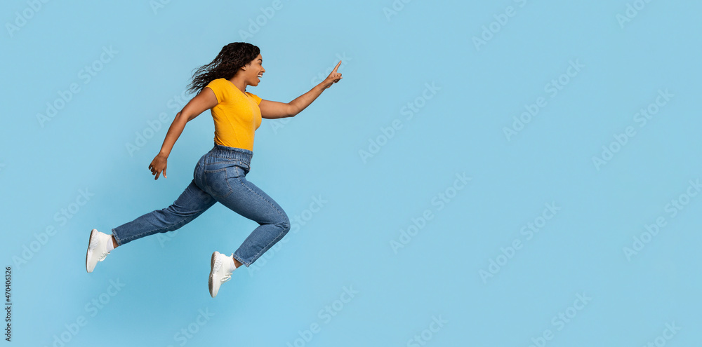 Excited black lady jumping towards copy space Excited black lady jumping towards copy space