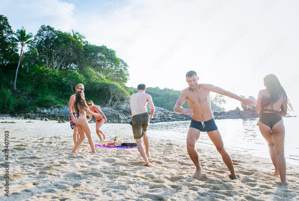 Group of friends having fun on the beach on a lonely island
