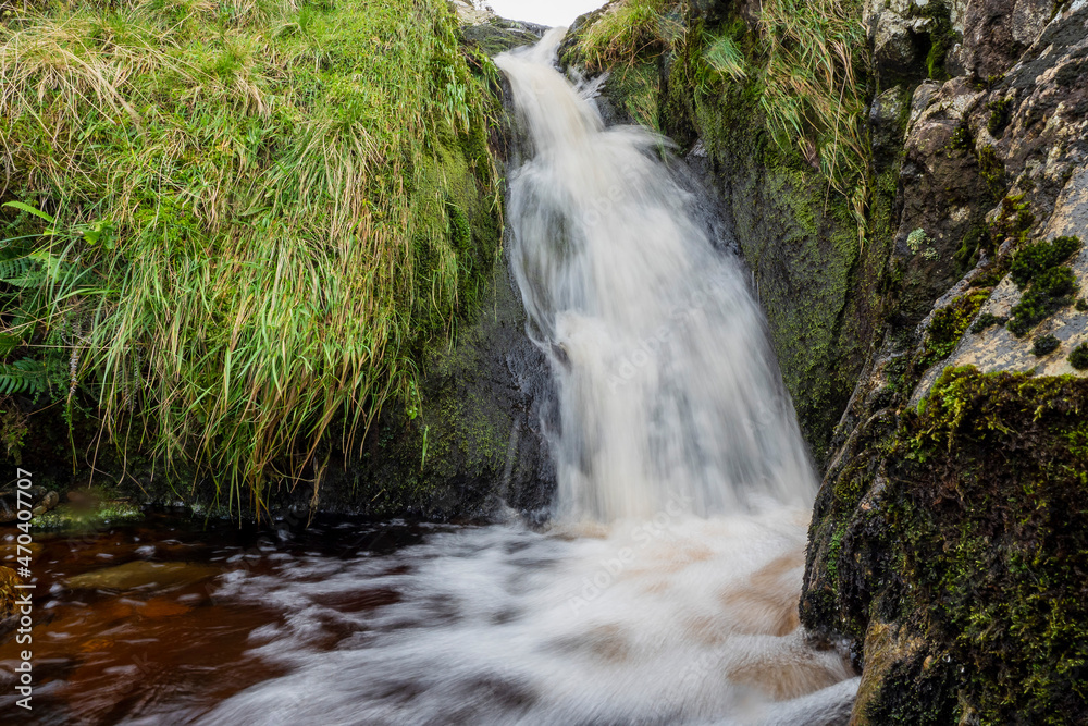 Fototapeta premium Small waterfall in a mountains. Beautiful nature scenery. Calm and peaceful atmosphere.