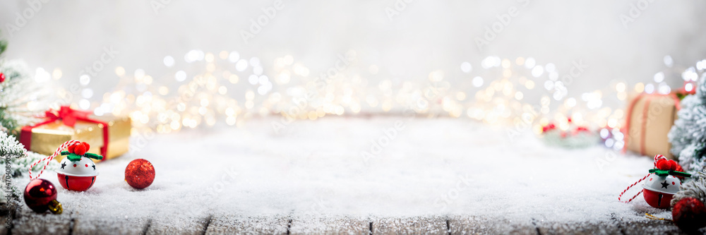 Banner with Christmas red decorations on snow with fir tree branches and christmas lights. Winter Decoration Background with copy space for text