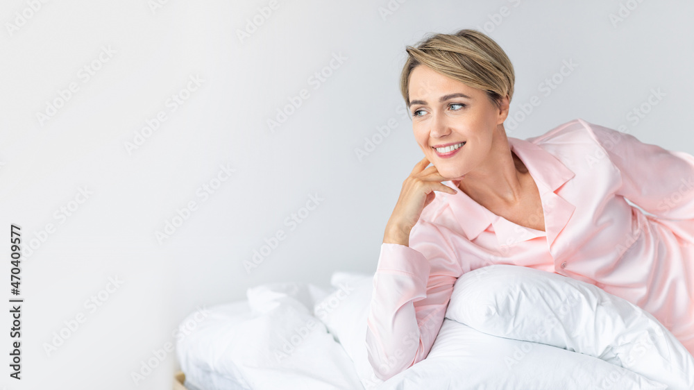 Happy woman looking away and thinking in bed Happy woman looking away and thinking in bed